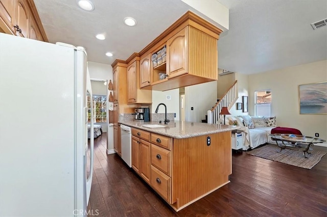 kitchen featuring sink, white fridge, light stone countertops, dark hardwood / wood-style flooring, and dishwashing machine