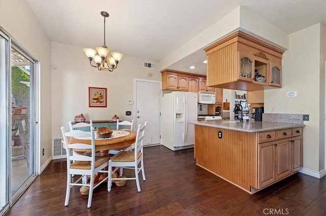 kitchen with white appliances, light stone counters, pendant lighting, a chandelier, and dark hardwood / wood-style flooring