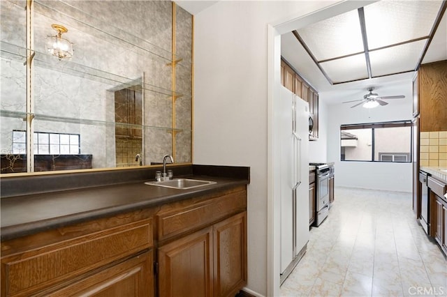 kitchen with sink, stainless steel range with gas stovetop, and ceiling fan