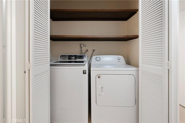 clothes washing area with washing machine and dryer