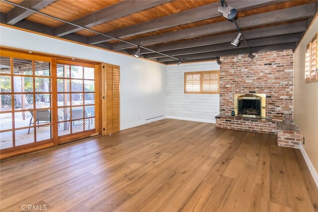 unfurnished living room featuring brick wall, light hardwood / wood-style flooring, wood ceiling, and beam ceiling