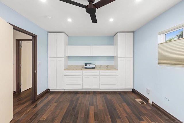 kitchen featuring white cabinets, ceiling fan, light stone counters, and dark hardwood / wood-style floors