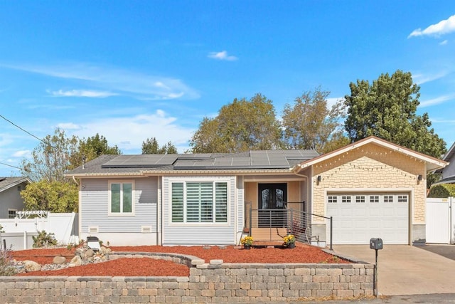 ranch-style home with solar panels and a garage