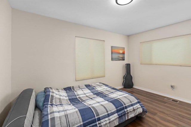 bedroom with dark hardwood / wood-style floors