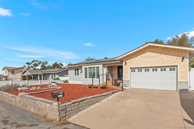 ranch-style home featuring a garage and solar panels