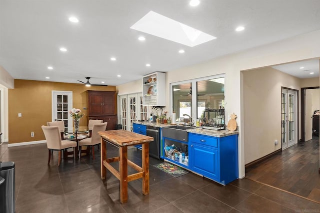 bar with dishwasher, a skylight, ceiling fan, light stone counters, and blue cabinets