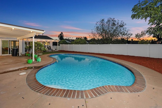 pool at dusk featuring a patio