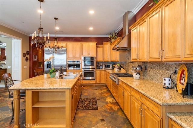 kitchen featuring sink, a kitchen island with sink, stainless steel appliances, decorative light fixtures, and wall chimney exhaust hood