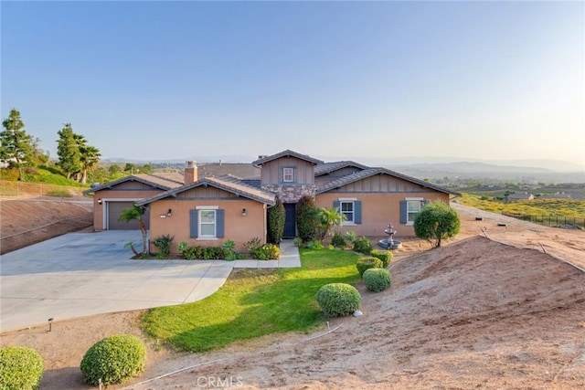 ranch-style house featuring a front yard, an attached garage, and driveway