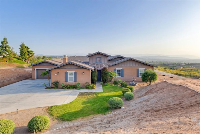 650 Crystal Mountain Cir, Riverside, CA 92506 - view of front of property featuring concrete driveway, a garage, a front lawn, stucco siding, and a chimney