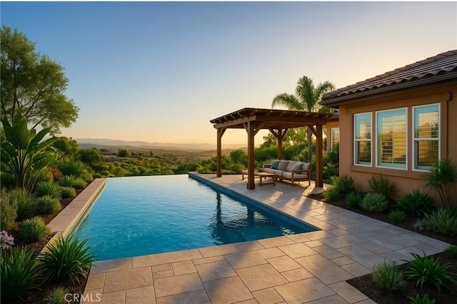 650 Crystal Mountain Cir, Riverside, CA 92506 - pool at dusk featuring a pergola, a patio, an outdoor living space, an infinity pool, and a mountain view
