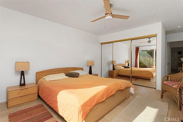 bedroom featuring a closet, light hardwood / wood-style flooring, and ceiling fan