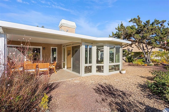 back of house featuring a sunroom and a patio