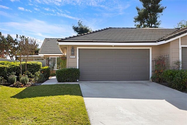 ranch-style home with a garage and a front lawn