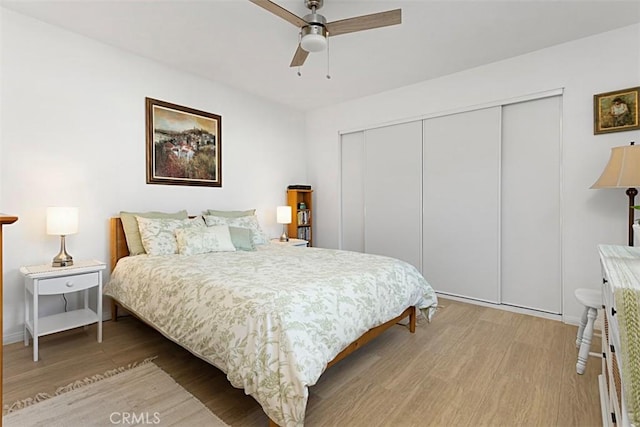 bedroom featuring ceiling fan, a closet, and light hardwood / wood-style flooring