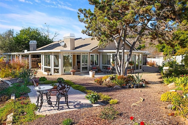 rear view of house featuring a sunroom and a patio