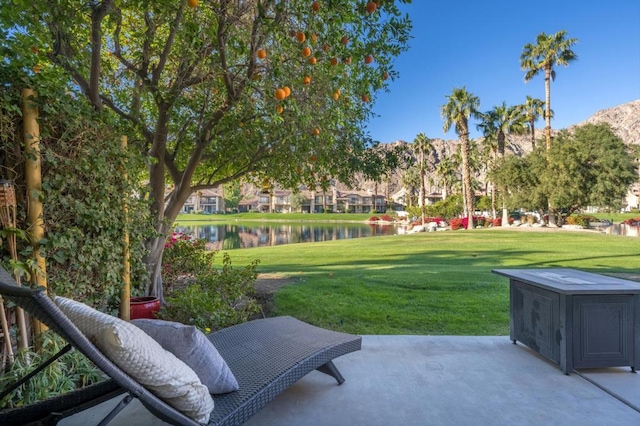 view of community featuring a patio, a water view, and a lawn