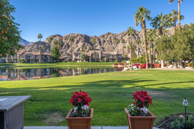 view of property's community with a yard and a water and mountain view