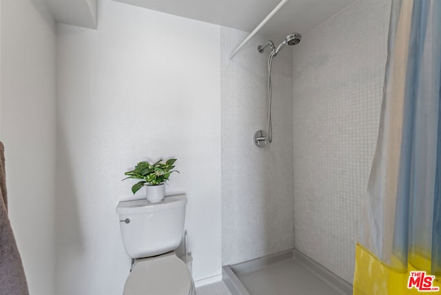 bathroom featuring a shower with shower curtain and toilet