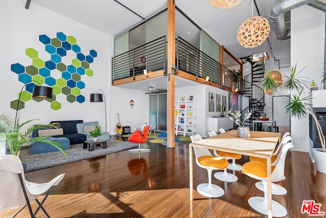 rec room with a towering ceiling and wood-type flooring