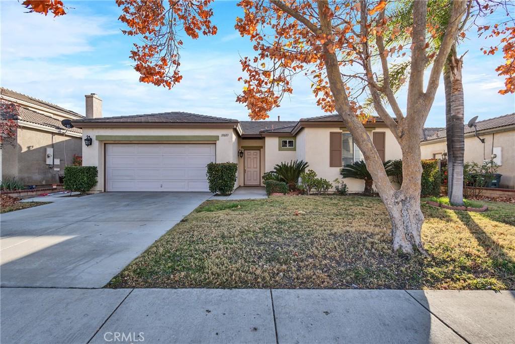 ranch-style home featuring a garage and a front lawn