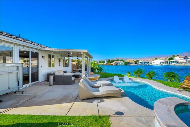 view of pool with ceiling fan, a patio, a water view, and outdoor lounge area