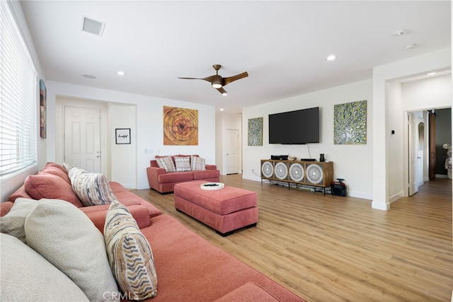 living room with ceiling fan and light hardwood / wood-style flooring