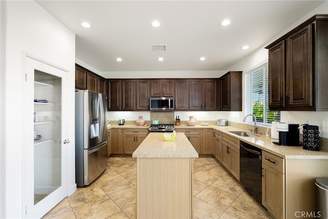 kitchen with stainless steel appliances, a kitchen island, and sink