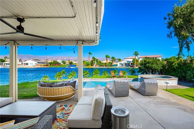 view of patio featuring an outdoor hangout area, ceiling fan, a swimming pool with hot tub, and a water view