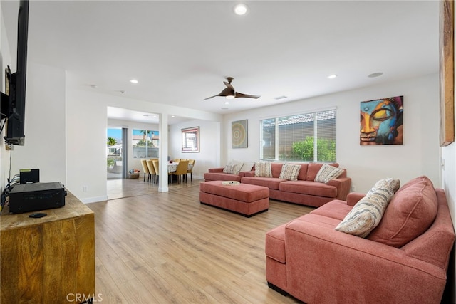 living room featuring ceiling fan, light hardwood / wood-style floors, and plenty of natural light