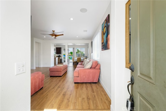 living room featuring ceiling fan and light hardwood / wood-style floors