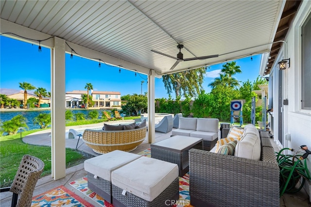 view of patio featuring a water view, ceiling fan, and an outdoor living space