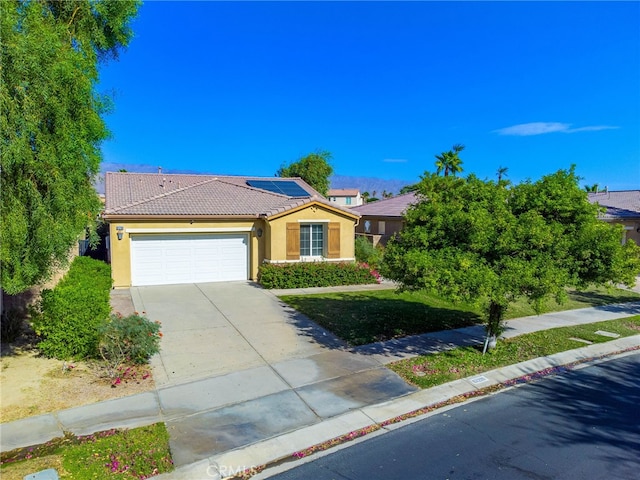 view of front of home with a garage and solar panels