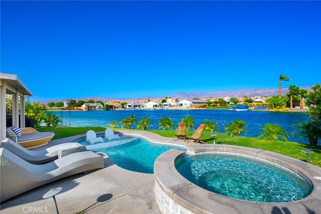 view of pool with a yard, an in ground hot tub, and a water view