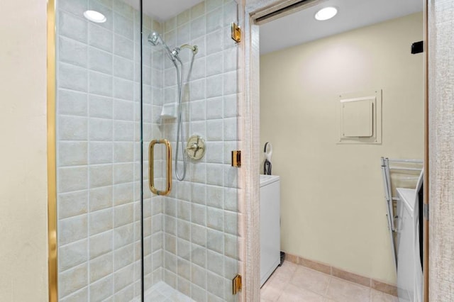 bathroom with tile patterned flooring, washer / clothes dryer, and a shower with shower door