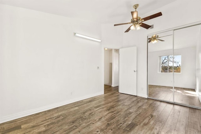 unfurnished bedroom with hardwood / wood-style flooring, ceiling fan, and a closet