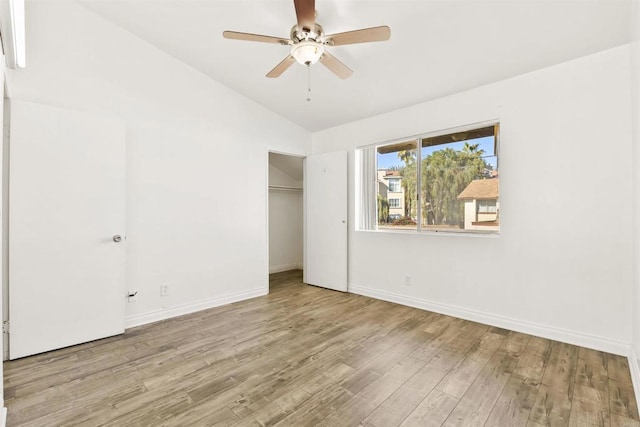 unfurnished bedroom with lofted ceiling, a closet, ceiling fan, and light hardwood / wood-style floors