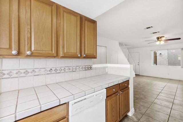 kitchen featuring ceiling fan, tile countertops, dishwasher, and light tile patterned floors