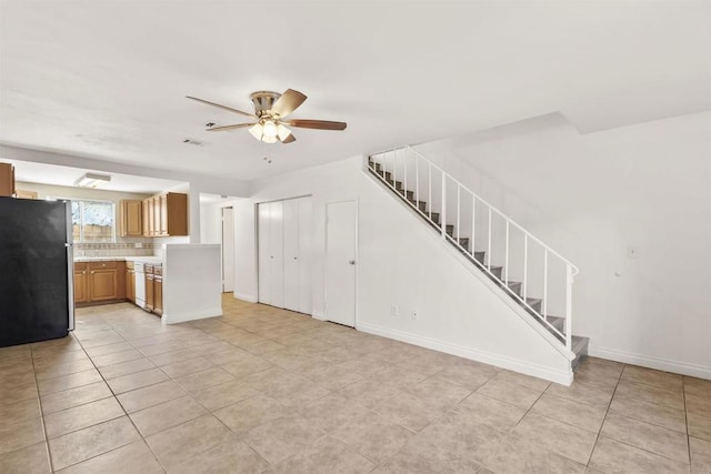 kitchen featuring ceiling fan, light tile patterned floors, tasteful backsplash, and stainless steel refrigerator