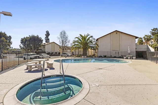 view of swimming pool featuring a patio area and a hot tub