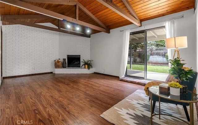 unfurnished living room featuring lofted ceiling with beams, brick wall, wood ceiling, hardwood / wood-style floors, and a fireplace