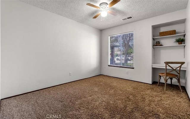 carpeted spare room with a textured ceiling and ceiling fan