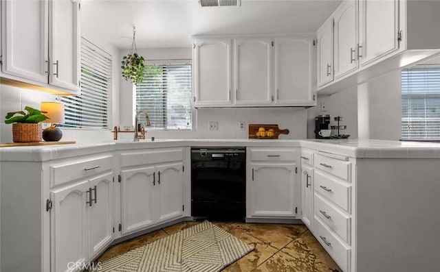 kitchen with black dishwasher, tile countertops, white cabinetry, and tasteful backsplash