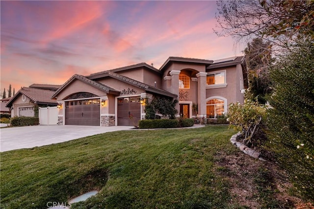 view of front of property featuring a garage and a lawn