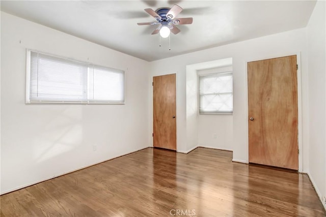 spare room with hardwood / wood-style flooring, a wealth of natural light, and ceiling fan