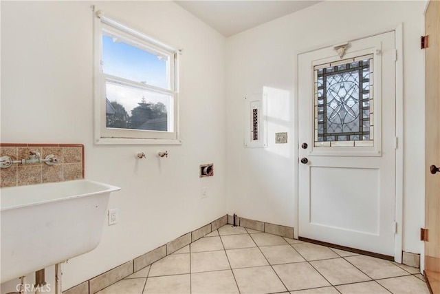 laundry room featuring electric dryer hookup, sink, hookup for a washing machine, and light tile patterned flooring