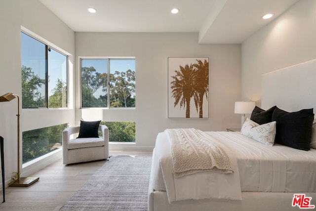 bedroom featuring multiple windows and light hardwood / wood-style flooring