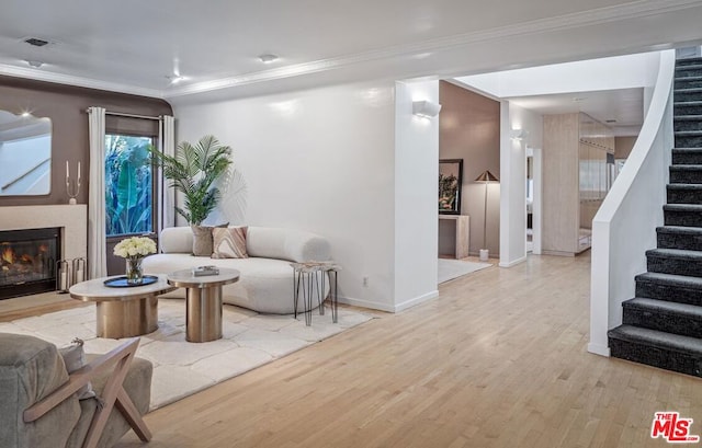 living room with light hardwood / wood-style floors and crown molding