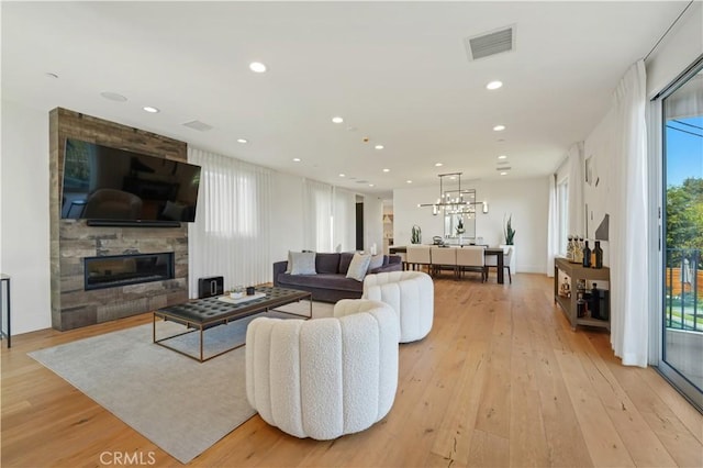 living room with a large fireplace and light hardwood / wood-style floors