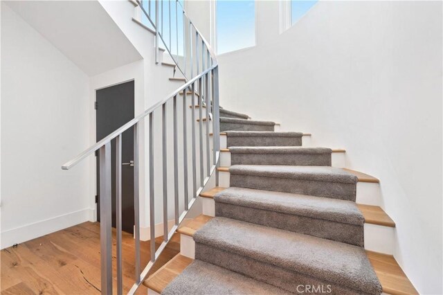 staircase with hardwood / wood-style floors